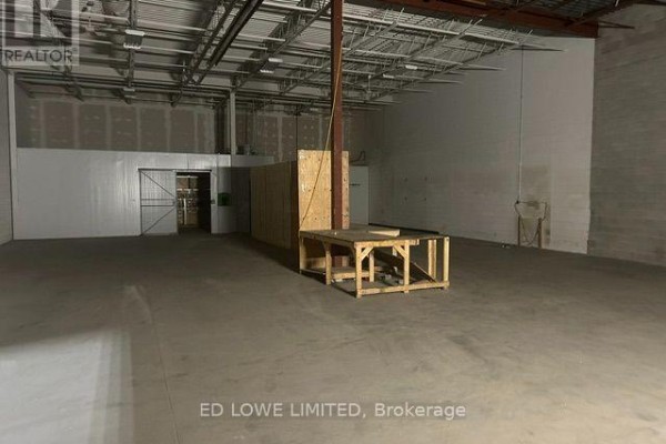 Large warehouse space with concrete floor, exposed ceiling beams, and storage structures. - 5 To 8 - 112 Saunders Road, Barrie