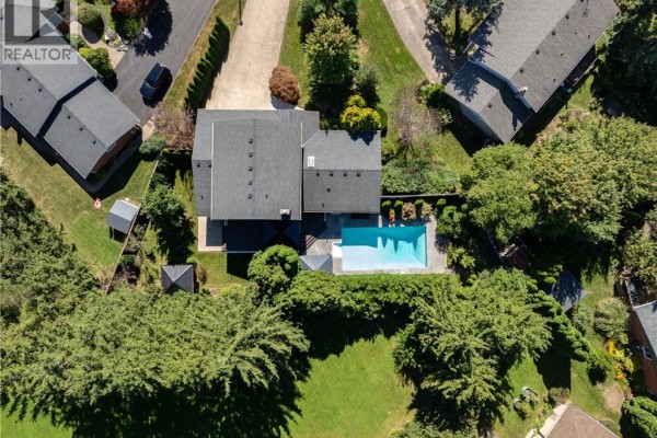 Aerial view of a backyard with a rectangular swimming pool, surrounded by manicured trees and lawn. - 5 Tottenham Court, Niagara On The Lake