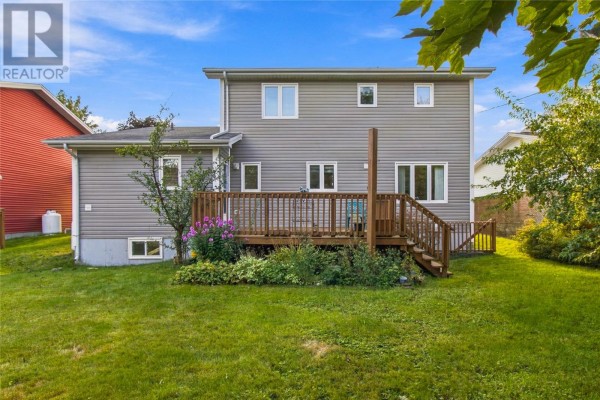 Back of a two-story grey vinyl siding home with a wooden deck and green lawn. - 5 Trafalgar Drive, Mount Pearl