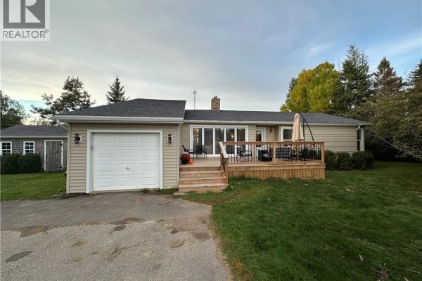Exterior of a beige bungalow with a garage, wooden deck, and surrounding green lawn. - 5 Valleyview Drive, Wards Creek