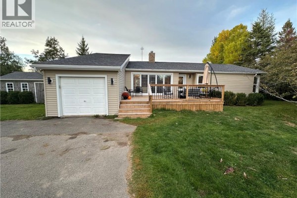Side view of the bungalow showing the garage, deck, and part of the backyard. - 5 Valleyview Drive, Wards Creek