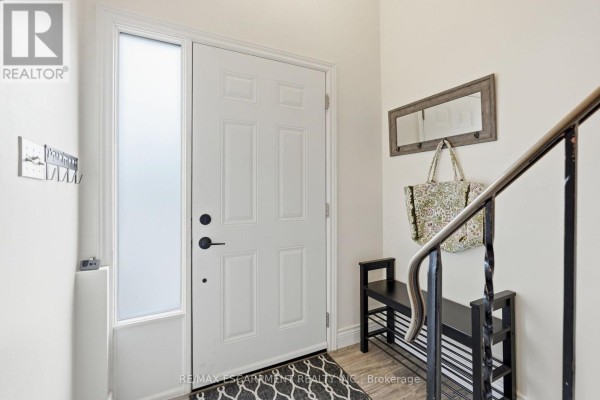 Interior entryway with white door, black bench, and mirror on wall. - 50 - 1115 Paramount Drive, Hamilton