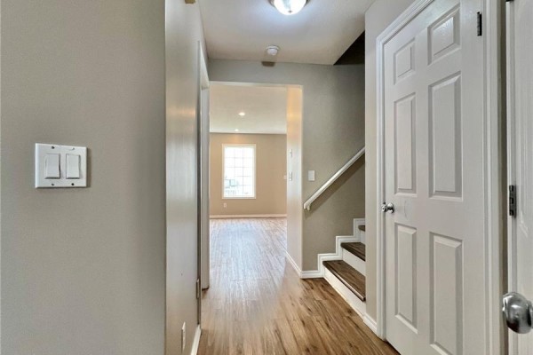 Small bathroom with vanity, granite countertop, and mirror next to hallway leading to living room. - 50 103 Banyan Crescent, Saskatoon