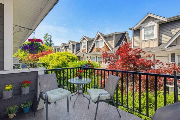 Balcony with seating, overlooking a row of townhouses and colorful foliage. - 50 15988 32 Avenue, Surrey