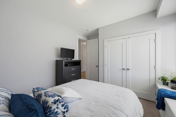 Bedroom with a queen bed, dresser, television, and large closet. - 50 15988 32 Avenue, Surrey