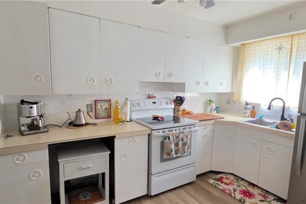 White kitchen cabinets, white countertops, and white appliances with a checkered curtain. - 50 Albany Street, Sudbury