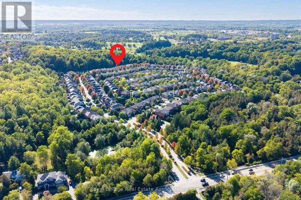 Aerial view of a suburban neighborhood with houses surrounded by trees and green space. - 50 Arborglen Drive, Halton Hills