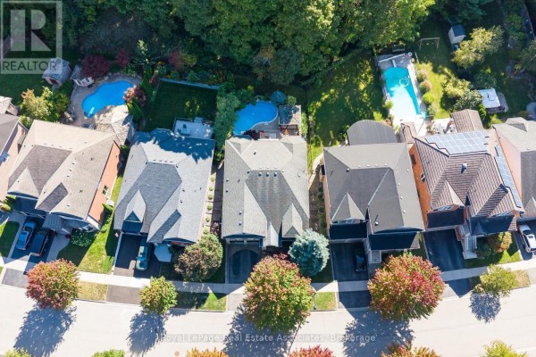 Overhead view of several houses with manicured backyards, one with a swimming pool. - 50 Arborglen Drive, Halton Hills