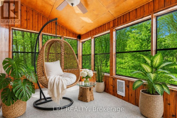 Aerial view of a large deck attached to the rear of a green house. - 50 Concession Rd 2 W, Tiny