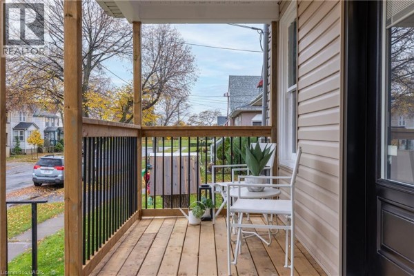 View from the porch looking out onto the street, showing seating and railing details. - 50 Fifth Street, Welland