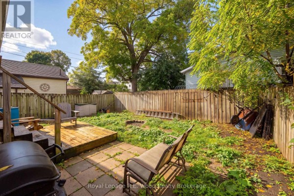 Backyard view with a wooden deck, patio area, lawn, and wooden fence. - 50 Flora Street, St  Thomas
