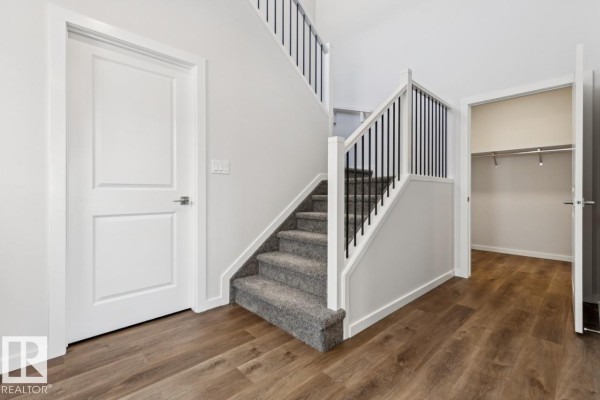 Walk-in closet with white shelving units on three walls and an adjacent doorway. - 50 Gambel Lo, Spruce Grove