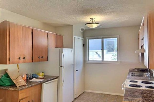 Kitchen with light wood cabinets, granite countertops, a white refrigerator, and a window. - 50 Jerry Potts Boulevard W, Lethbridge