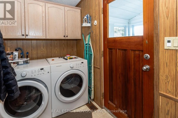 Washer, dryer, cabinets, and wooden door in laundry room - 50 Juno Crescent Georgina