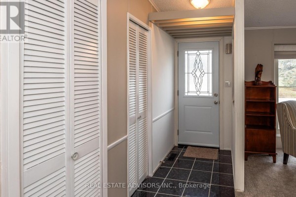 Bedroom with a queen-sized bed, mirrored closet doors, and a sliding glass door. - 50 Juno Crescent, Georgina