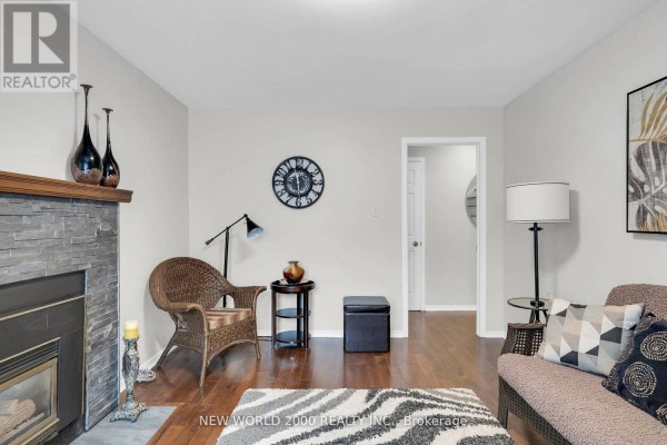 Living room with fireplace, wicker chair, and sofa - 50 Livingstone Street W Barrie