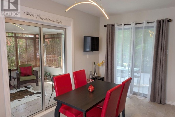 Dining room with red chairs, black table, modern light, and sunroom - 50 Livingstone Street W Barrie