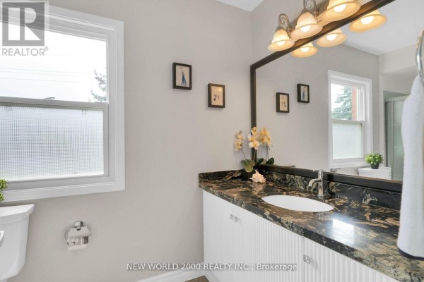 Bathroom vanity with granite countertop, vessel sink, and vanity light fixture - 50 Livingstone Street W Barrie