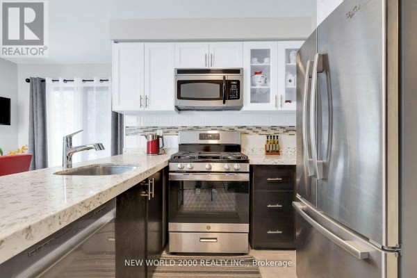 Modern kitchen with granite counters, stainless steel appliances, and dark cabinets - 50 Livingstone Street W Barrie