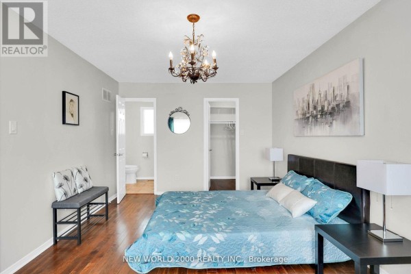 Bedroom with blue floral bed, chandelier, and ensuite bathroom access - 50 Livingstone Street W Barrie