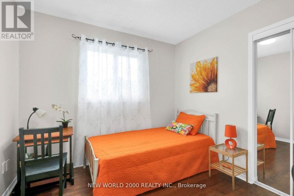 Bedroom with single bed, orange quilt, desk, and mirrored closet - 50 Livingstone Street W Barrie
