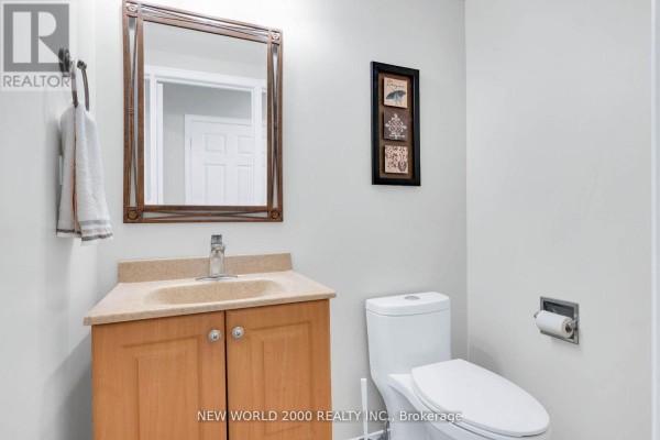 Bathroom with wooden vanity, sink, toilet and mirror - 50 Livingstone Street W Barrie