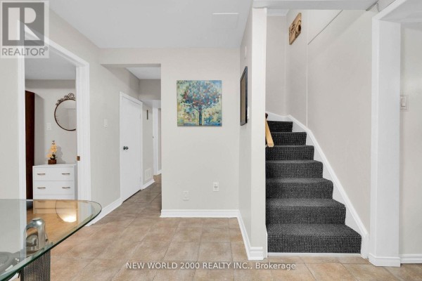 Hallway with tiled floor, carpeted stairs, and artwork - 50 Livingstone Street W Barrie