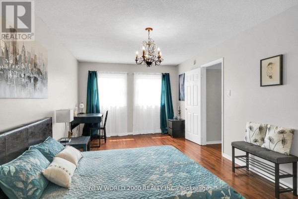 Bedroom with king bed, desk, chandelier, and teal curtains - 50 Livingstone Street W Barrie