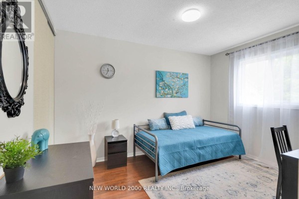 Blue daybed with quilt and pillows, nightstand, clock, and artwork - 50 Livingstone Street W Barrie