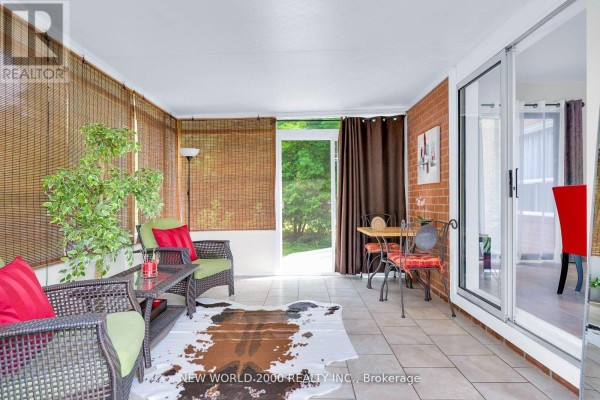 Sunroom with wicker furniture, cowhide rug, dining set, brick wall - 50 Livingstone Street W Barrie
