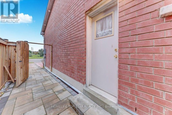 Side exterior of brick house with wooden fence and paved walkway. - 50 Marydale Avenue S, Markham