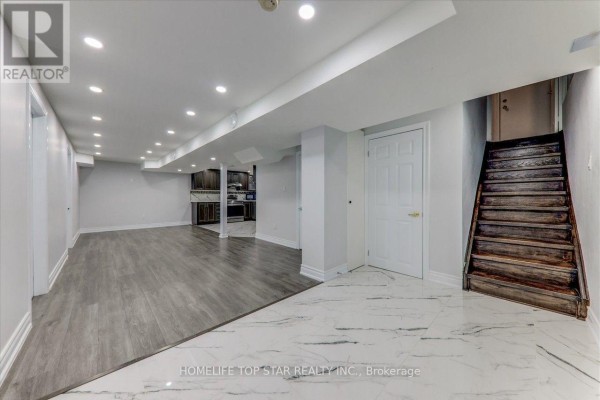 Finished basement with white walls, gray laminate and white marble tile floors. - 50 Marydale Avenue S, Markham