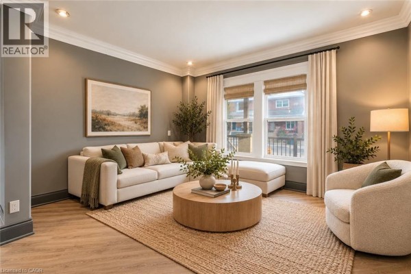 Living room with a large sectional sofa, armchair, round coffee table, jute rug, and large window. - 50 Somerset Avenue, Hamilton