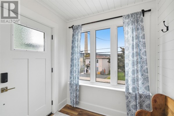 Interior entryway with white door, patterned curtains, and a view of houses. - 50 St. Clare Avenue, St  John S