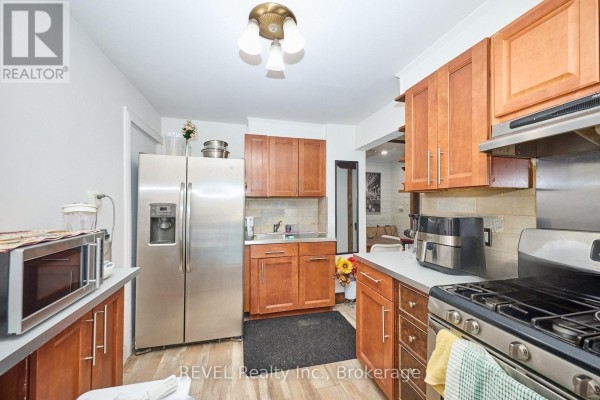 Kitchen with stainless steel refrigerator, wooden cabinets, and stainless steel gas stove. - 50 Welland Avenue, St  Catharines