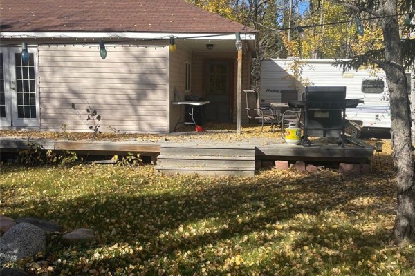 Open-concept living area with couch, kitchen, and storage - 500 Amisk Lane, Turtle Lake