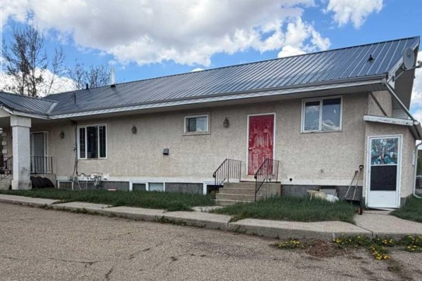 Bathroom with white tiles, red accents, and a shower-tub combination. - 5001 62 Avenue, Ponoka