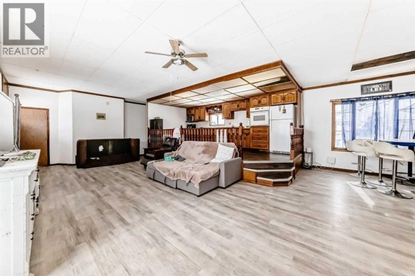 Entryway with a red front door, laminate flooring, and storage closet. - 5001 62 Avenue, Ponoka