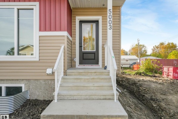 Close-up of the front entrance with steps, a glass-paneled door, and siding of a two-story home. - 5003 51 Av, Calmar