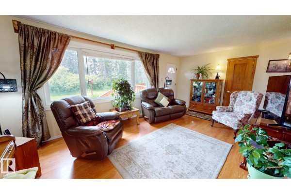 Side view of wooden deck with storage underneath and stairs. - 5004 50 Av, Evansburg