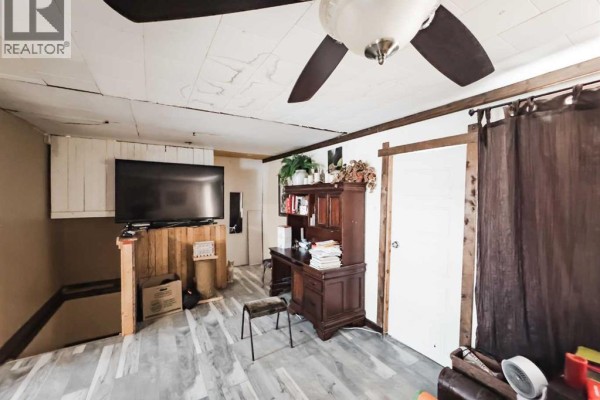 Small detached garage with wooden double doors, partially covered in snow. - 5008 Tardiff Avenue, Fort Vermilion