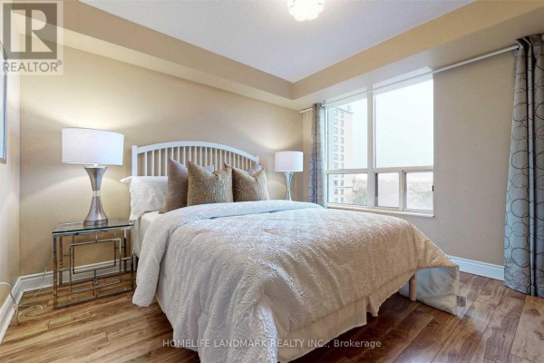 Bedroom with a queen-size bed, nightstands, lamps, and a large window with curtains. - 501 - 10 Northtown Way, Toronto