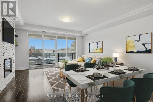 Dining area and living room with large windows overlooking the city. - 501 - 150 Wellington Street E, Guelph
