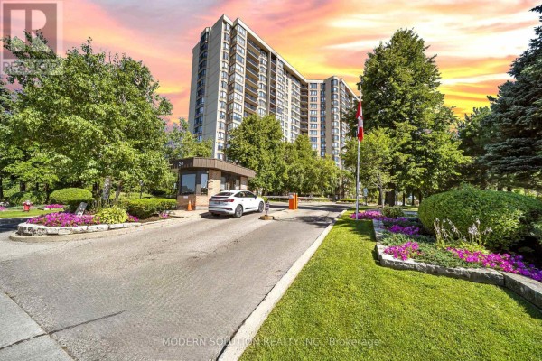 Apartment building entrance with a security booth and gate. - 501 - 20 Cherrytree Drive, Brampton