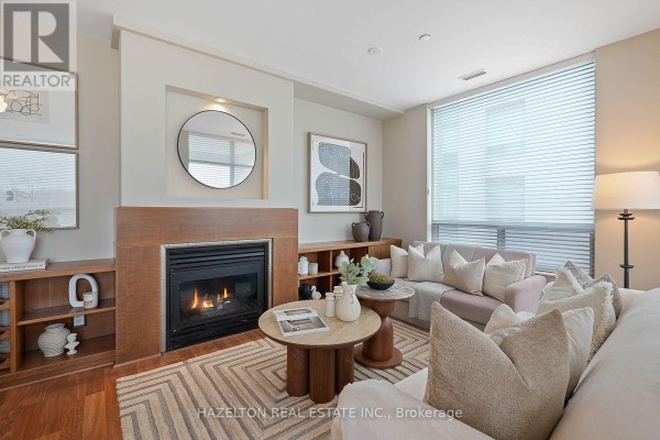 Living room featuring a fireplace, seating area with sofas, and large windows. - 501 - 980 Yonge Street, Toronto