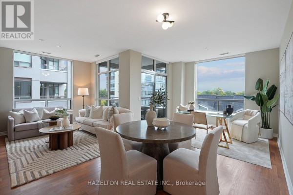 Open concept living and dining area with large windows, circular dining table, and seating. - 501 - 980 Yonge Street, Toronto