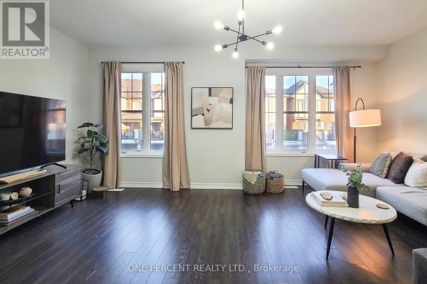 Living room with dark hardwood floors, beige curtains, a sectional sofa, and a television on a media stand. - 501 Buckeye Court, Milton