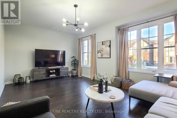 Living room with dark hardwood floors, neutral-toned sectional sofa, large windows with beige curtains, and a modern chandelier. - 501 Buckeye Court, Milton