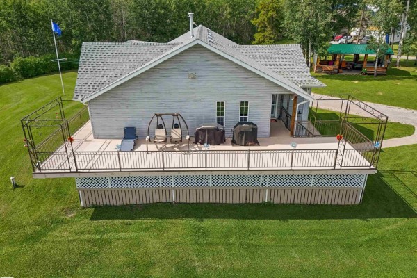 Side view of a detached garage with a gravel driveway and surrounding trees. - 50128 Hwy 22, Rural Brazeau County