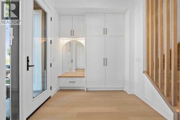 Interior entryway with white storage cabinets, bench seating, and wood accent wall. - 5014 22 Street, Calgary